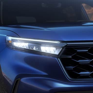 2027 Honda CR-V Sport Touring Hybrid in Canyon River Blue Metallic front close up of LED headlights (Compact Crossover SUV).